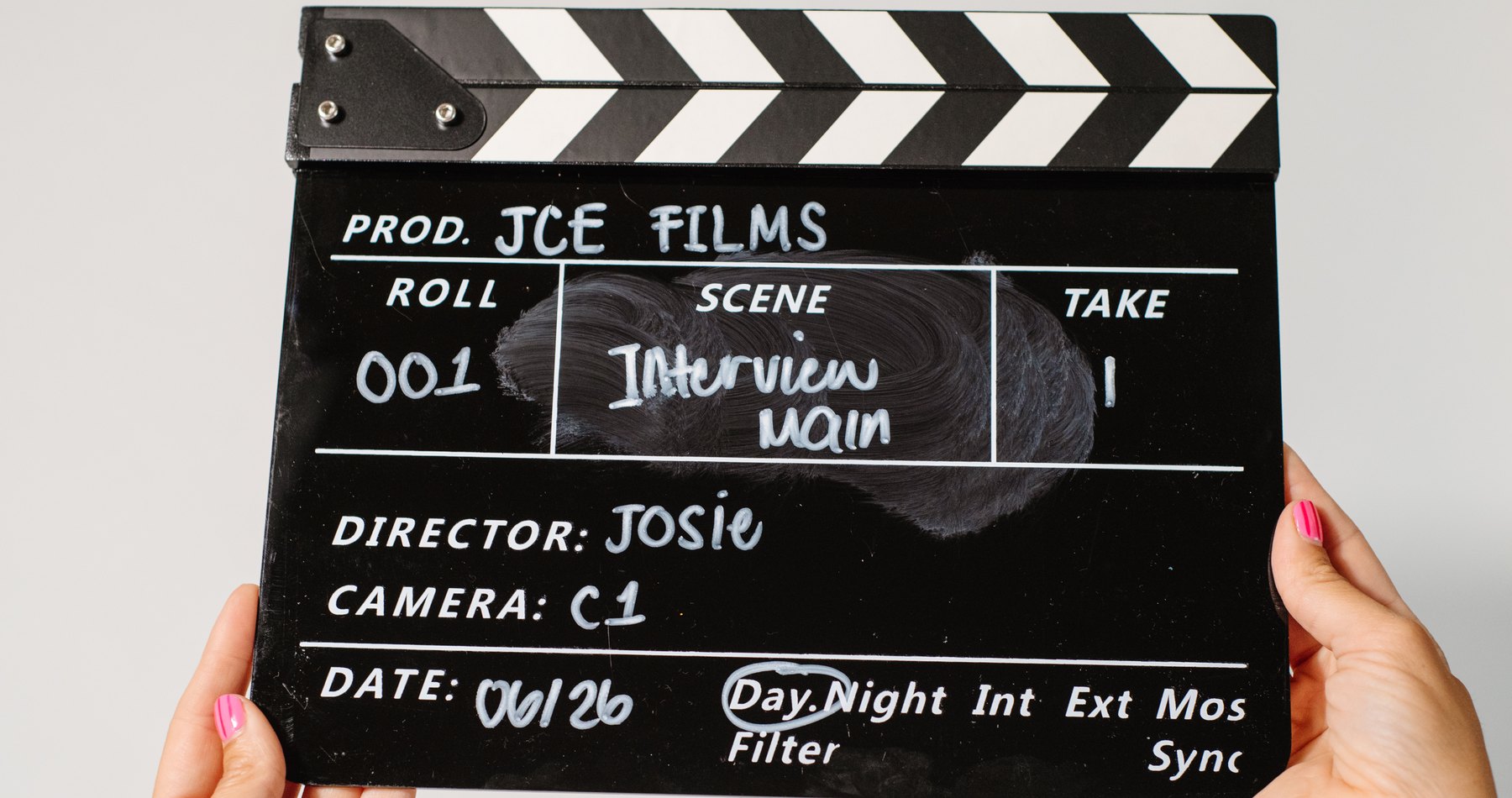 A JCE Films clapperboard held up before an interview
