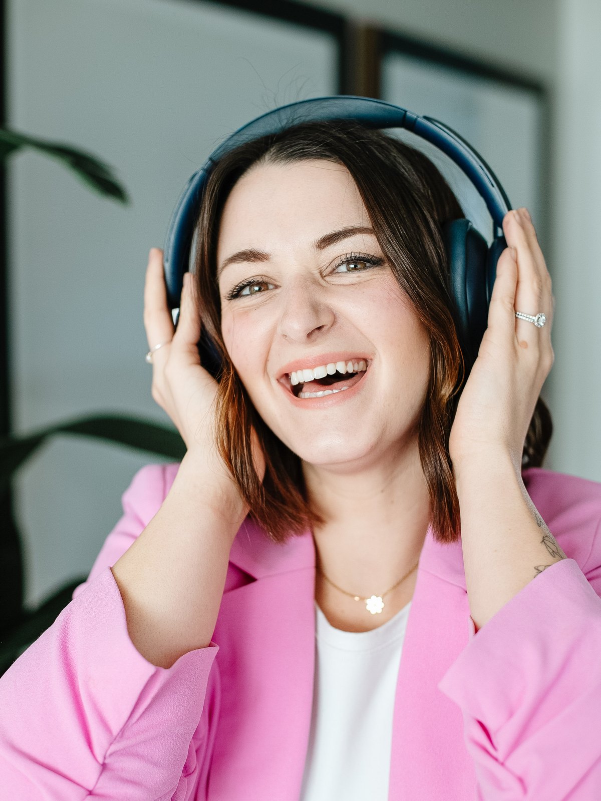 Josie Storbakken laughing, wearing headphones, in her studio